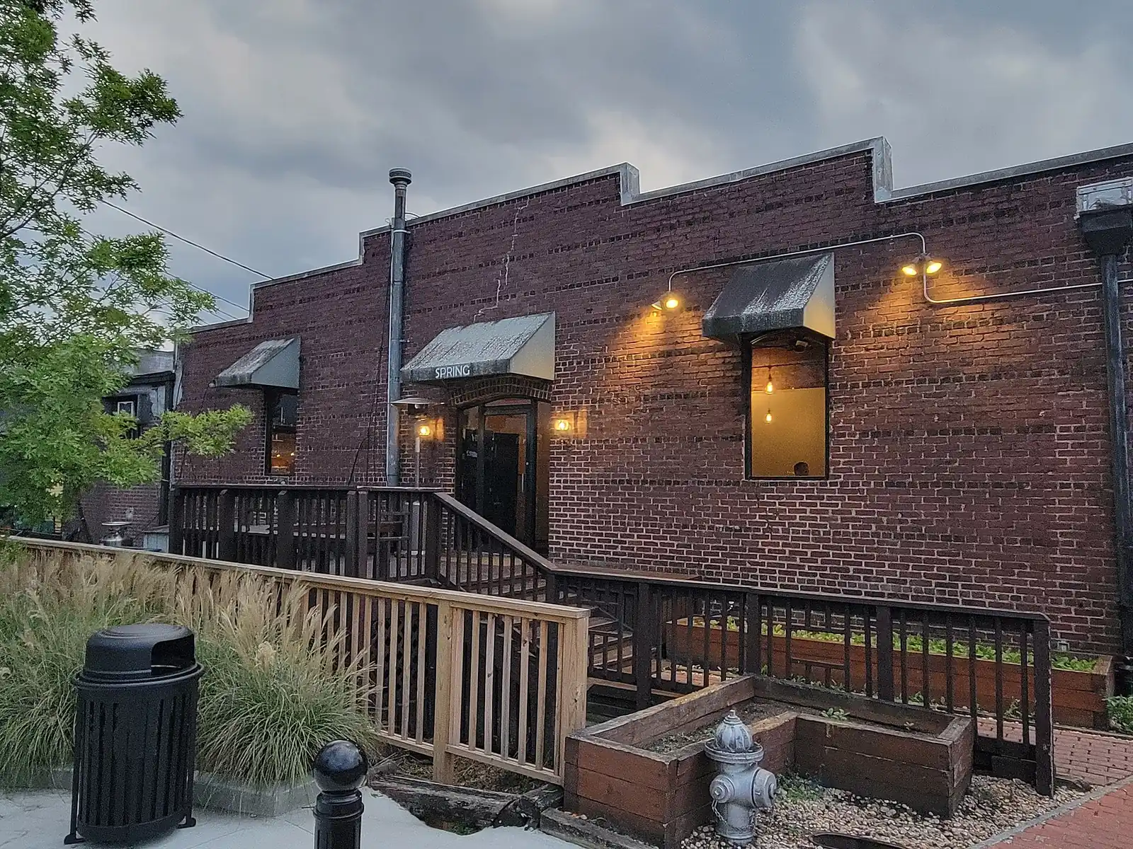 Lights glow on the brick front and deck of Spring restaurant on Mill Street in Marietta
