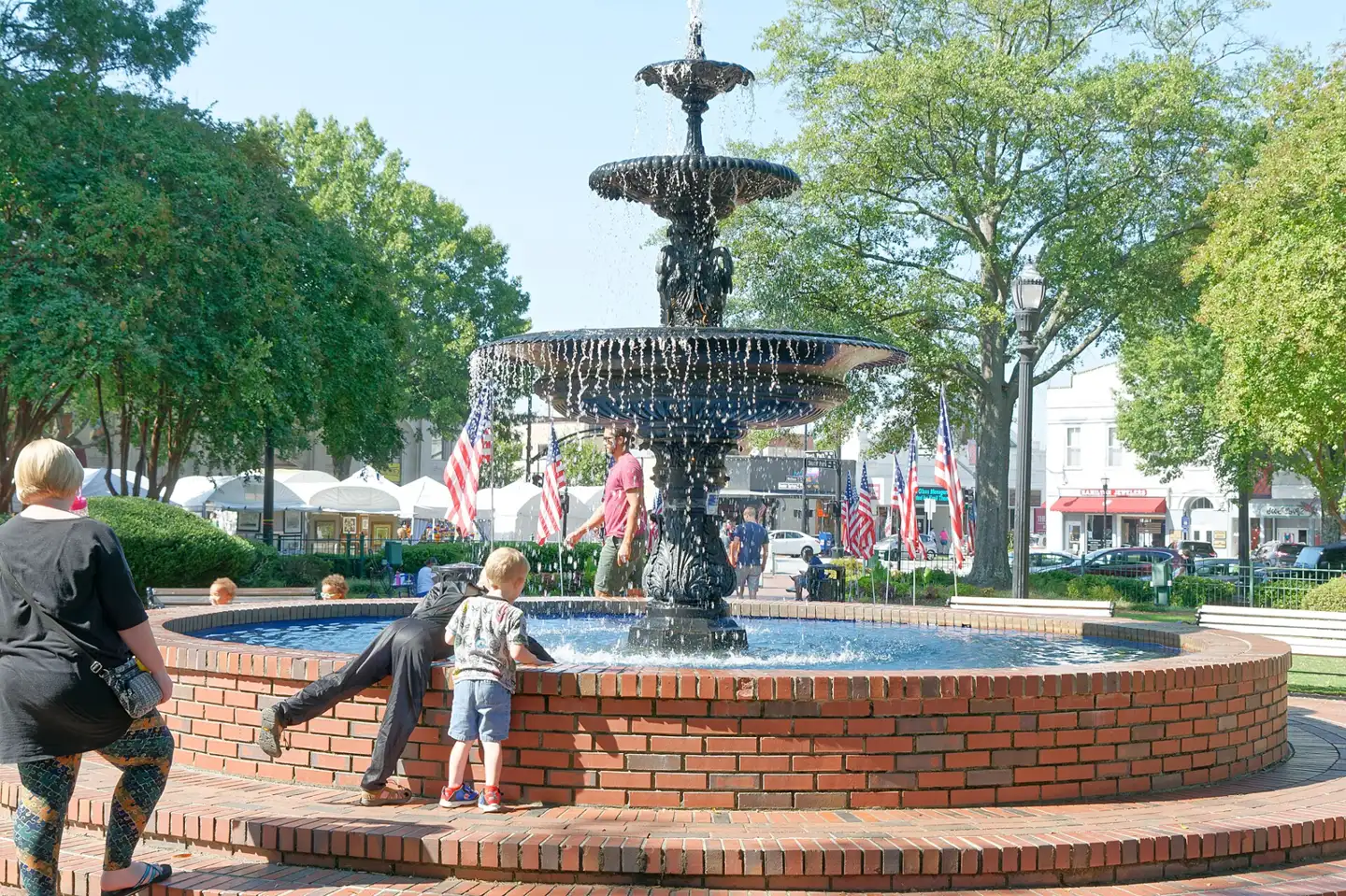 The fountain in Glover Park on Marietta Square, with American flags around the park