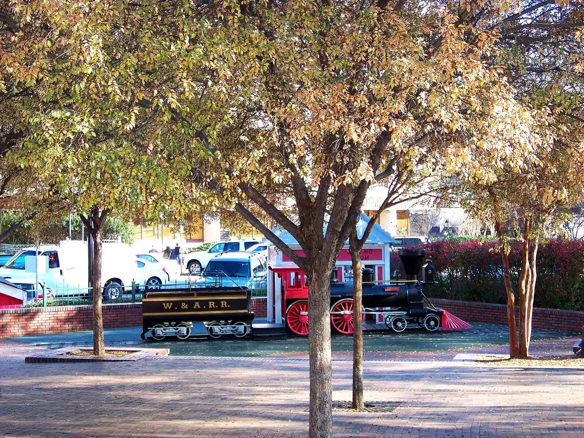 A model locomotive marked W.&A.R.R. among the trees in Glover Park on Marietta Square
