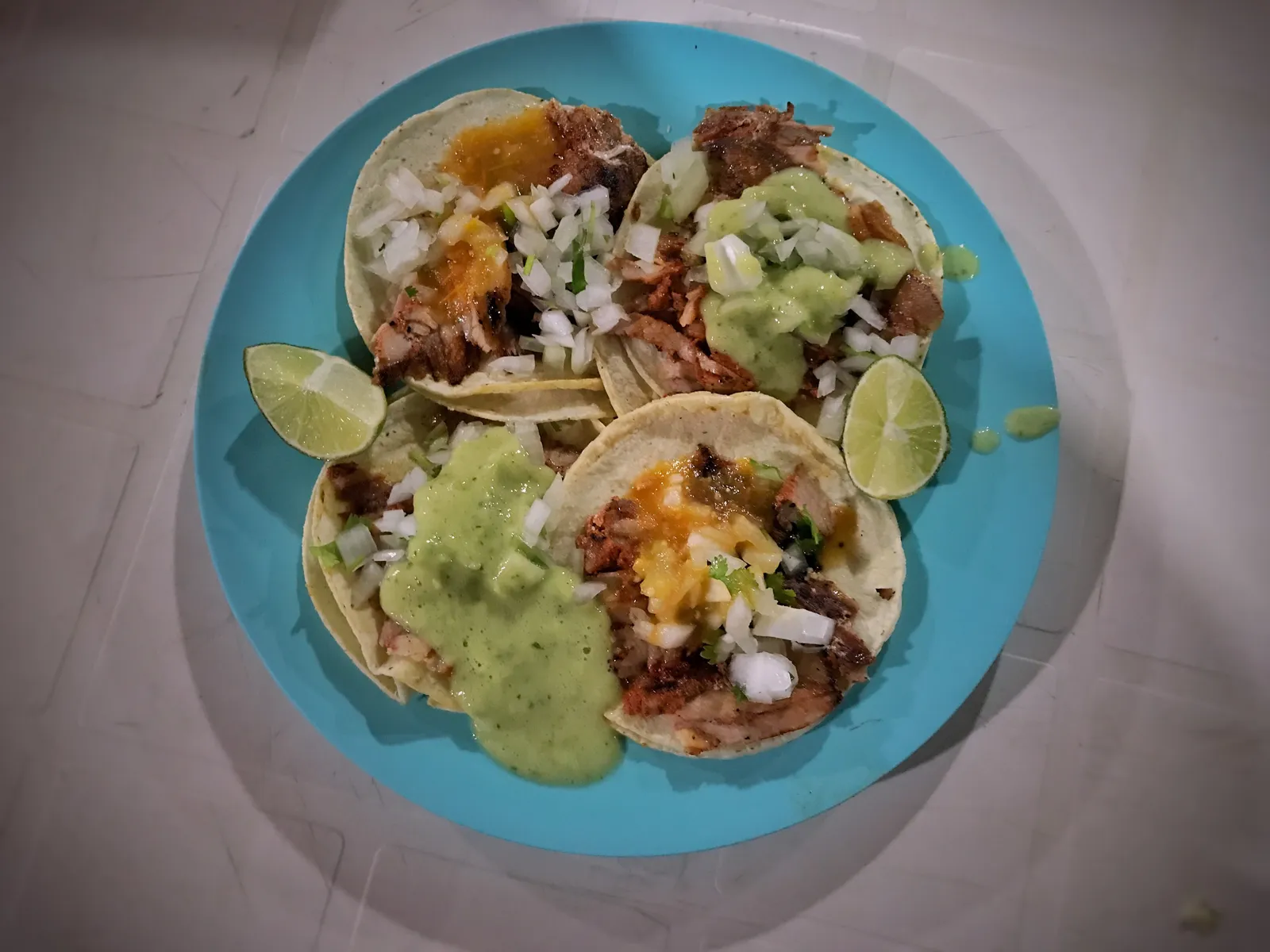 A plate of al pastor tacos with onion, cilantro, salsa and lime. The photo was not taken at a Marietta restaurant.