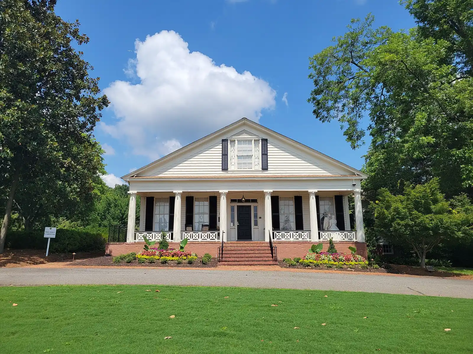 Brumby Hall, with its columned front porch and spring flower beds, on Powder Springs Street in Marietta