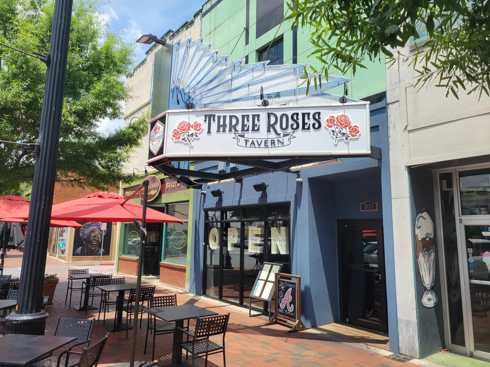 Three Roses Tavern on North Park Square in Marietta, with sidewalk tables and umbrellas along the block