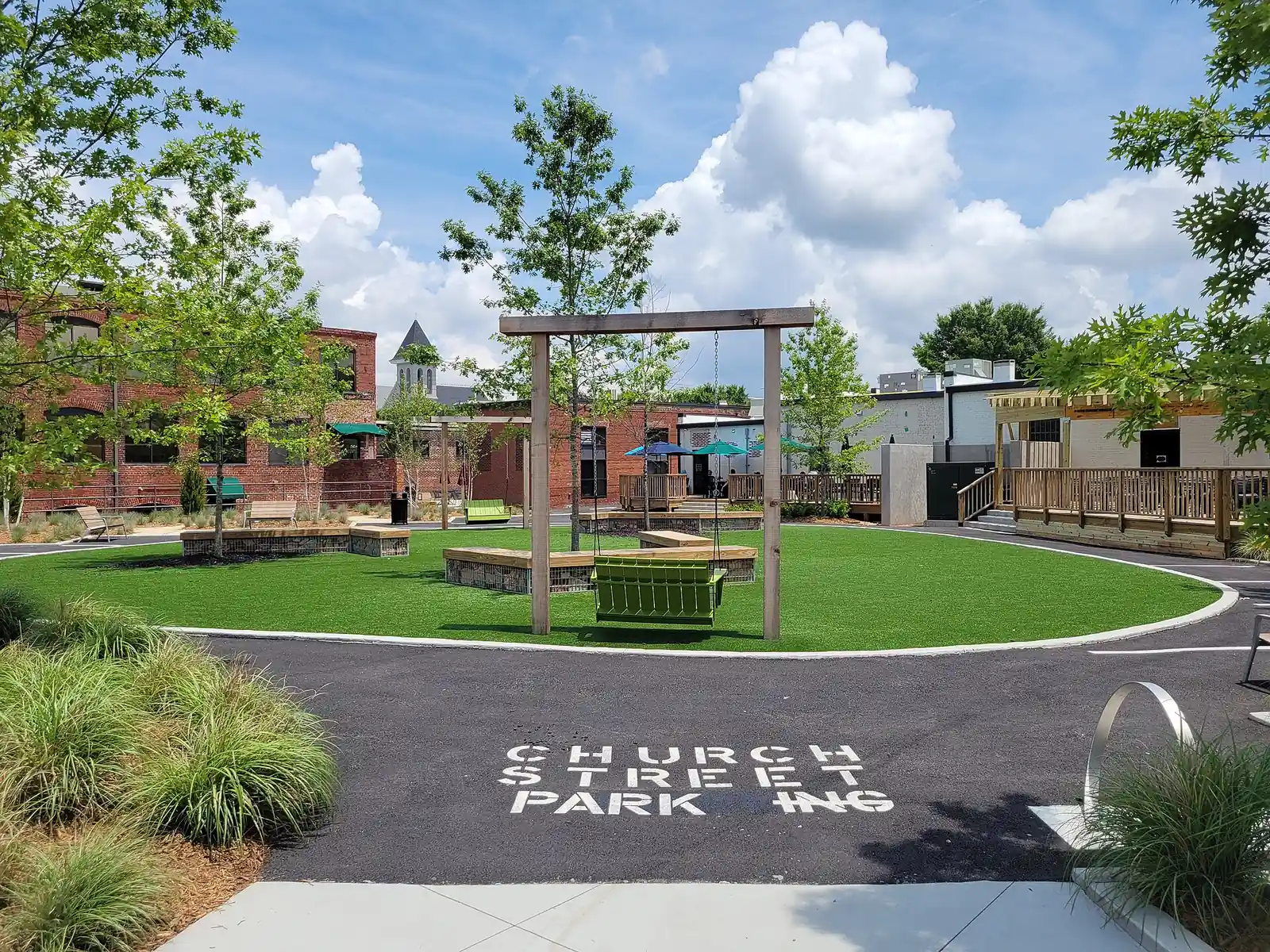 The lawn, swing and shade structures at Church Street Park in downtown Marietta, home of free summer movie nights