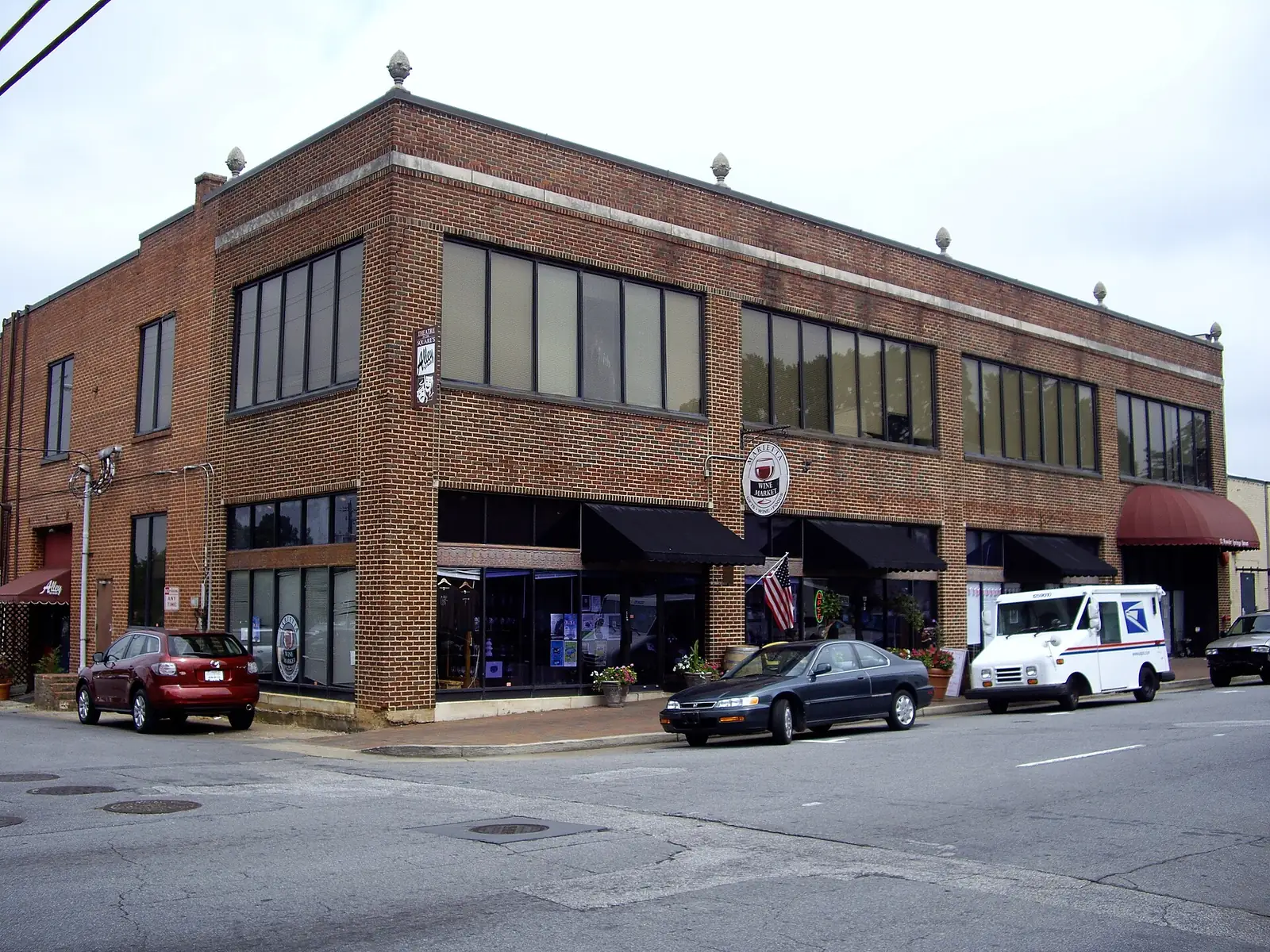 The brick building near Marietta Square that houses the Marietta Wine Market, with a sign for Theatre in the Square's Alley Stage